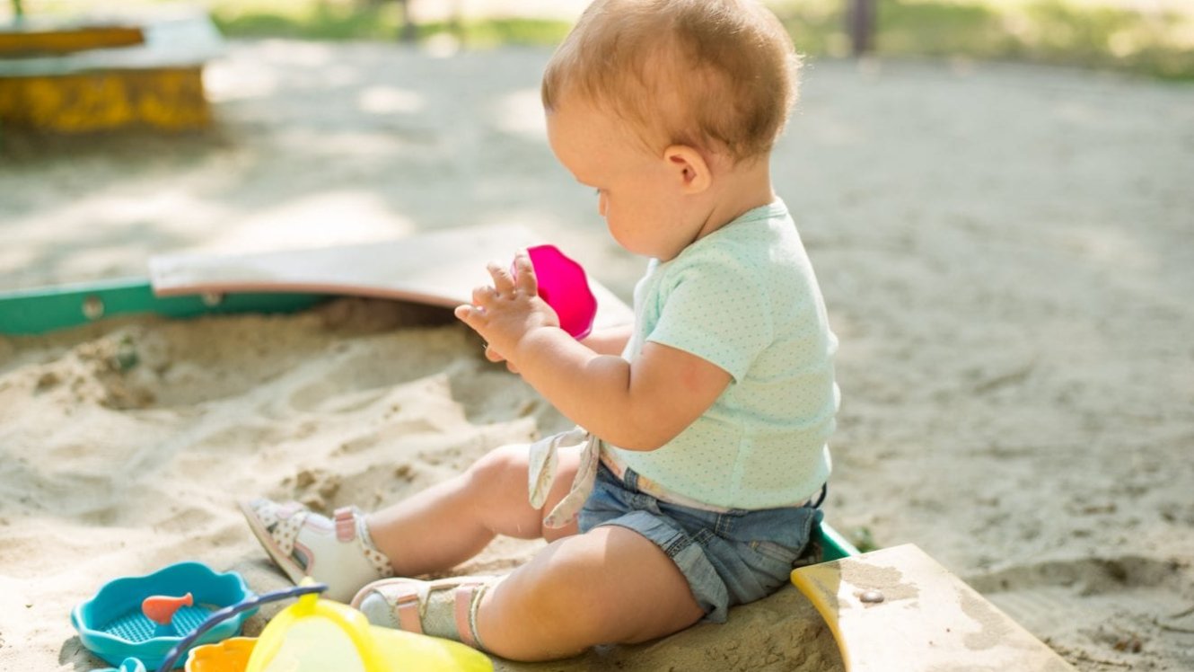 Lapsen käsi pinoaa Duploja.